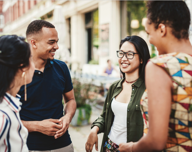 Group of happy young people talking on a sidewalk
